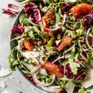 A simple Radicchio Salad in a bowl with romaine, arugula, grapefruit slices, and a homemade vinaigrette.