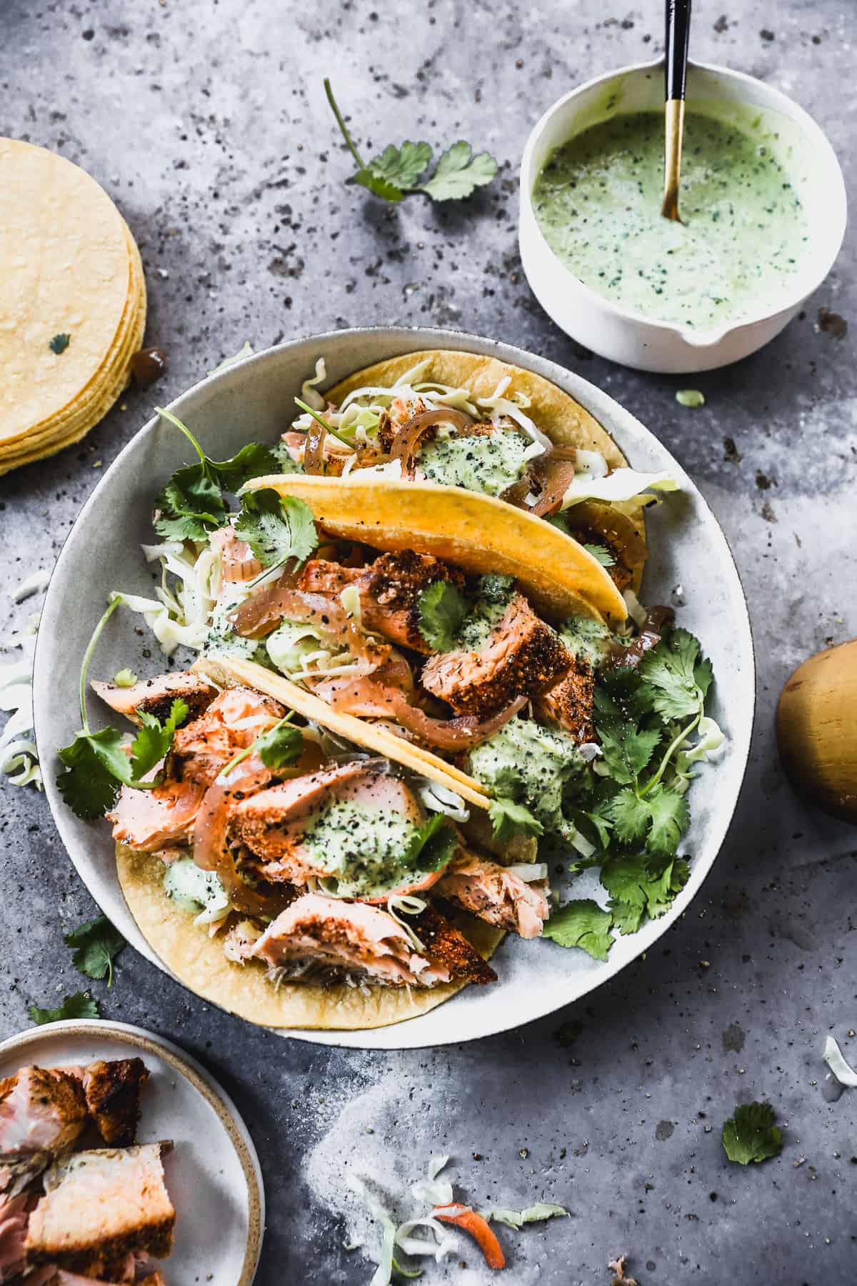 Three Blackened Salmon Tacos in corn tortillas on a plate, ready to enjoy. 