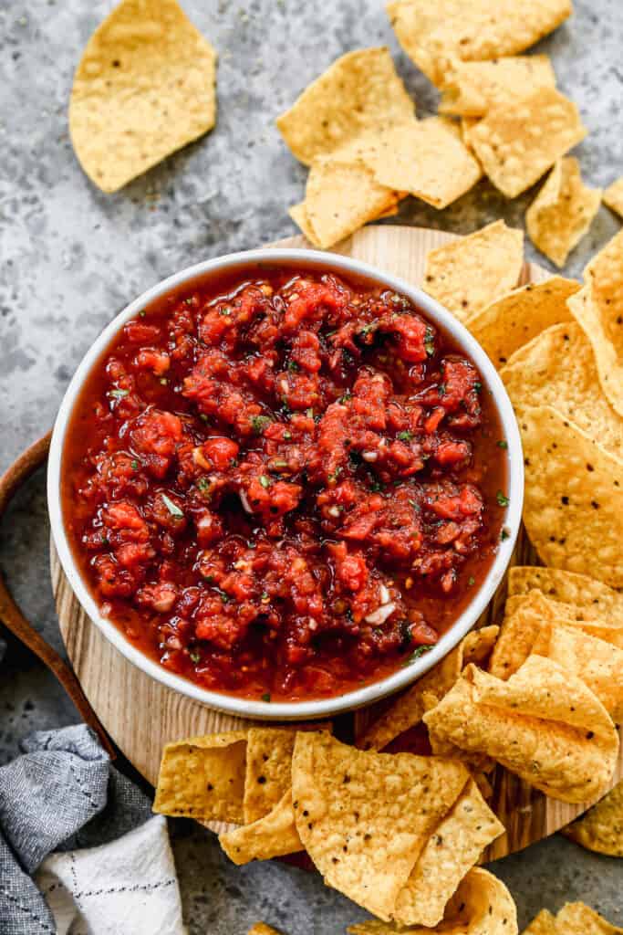 Homemade salsa served in a bowl with tortilla chips on the side.