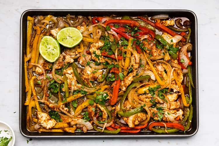 Cooked sheet pan fajitas on a sheet pan.