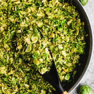 A shredded brussels sprouts recipe in a pan, sautéed with oil and garlic and ready to serve.