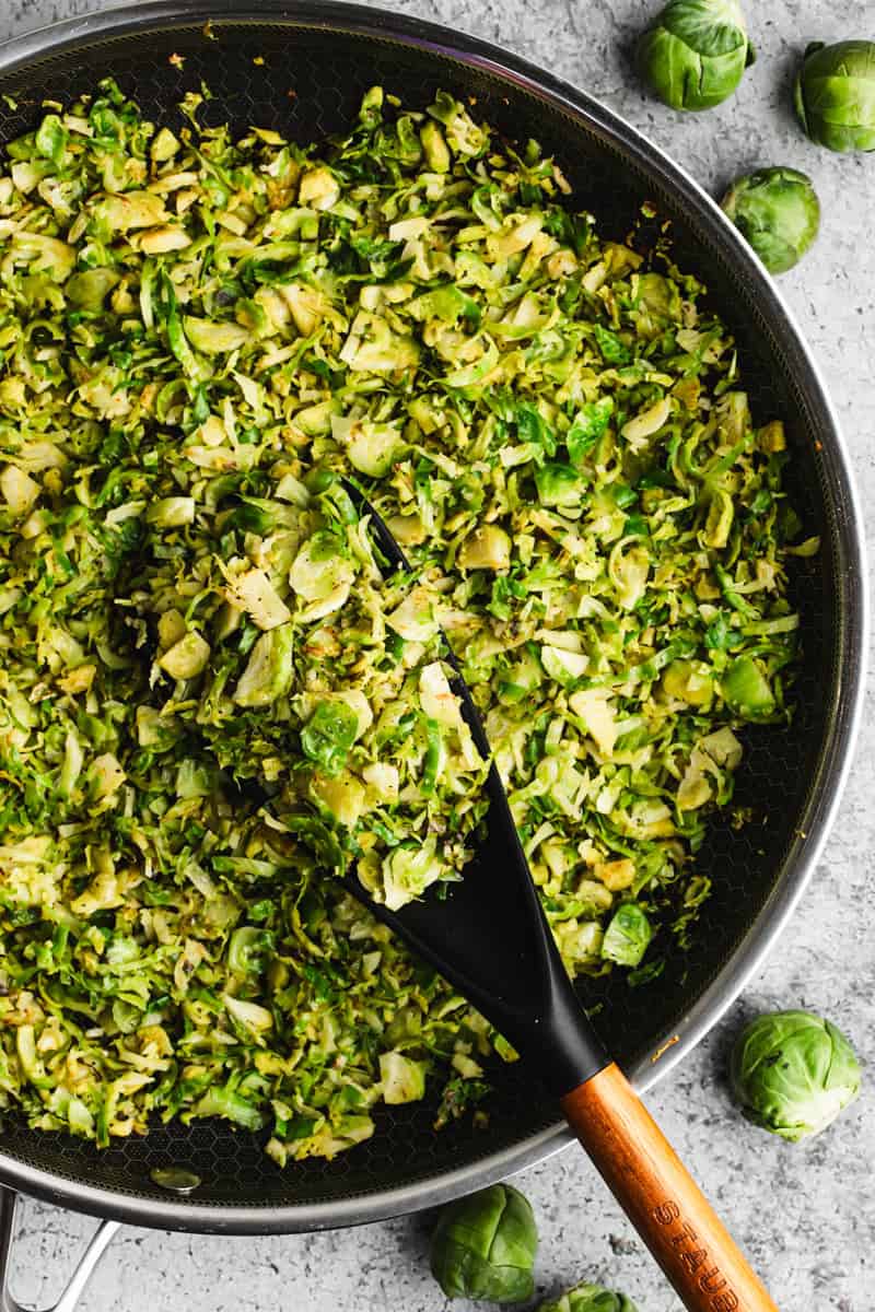 A shredded brussels sprouts recipe in a pan, sautéed with oil and garlic and ready to serve. 