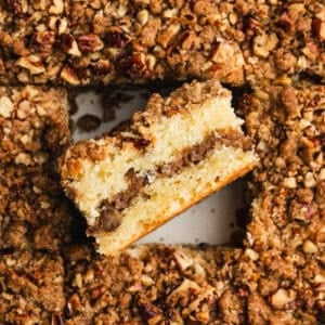 The best ever Sour Cream Coffee Cake recipe baked in a pan with the middle piece on the side to show the streusel layer baked inside.