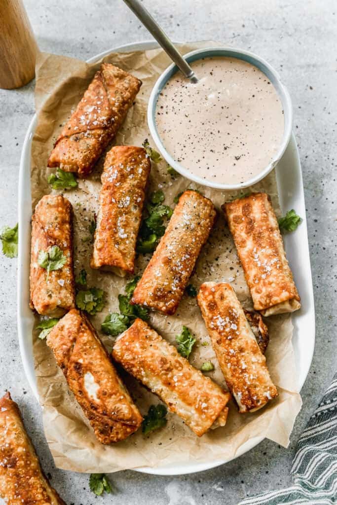 A platter with southwest egg rolls and dipping sauce.