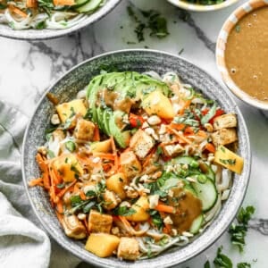 A fresh Spring Roll Bowl topped with a homemade peanut sauce in a serving bowl.