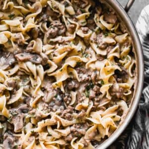 A skillet with stroganoff and egg noodles, cooked and ready to eat.