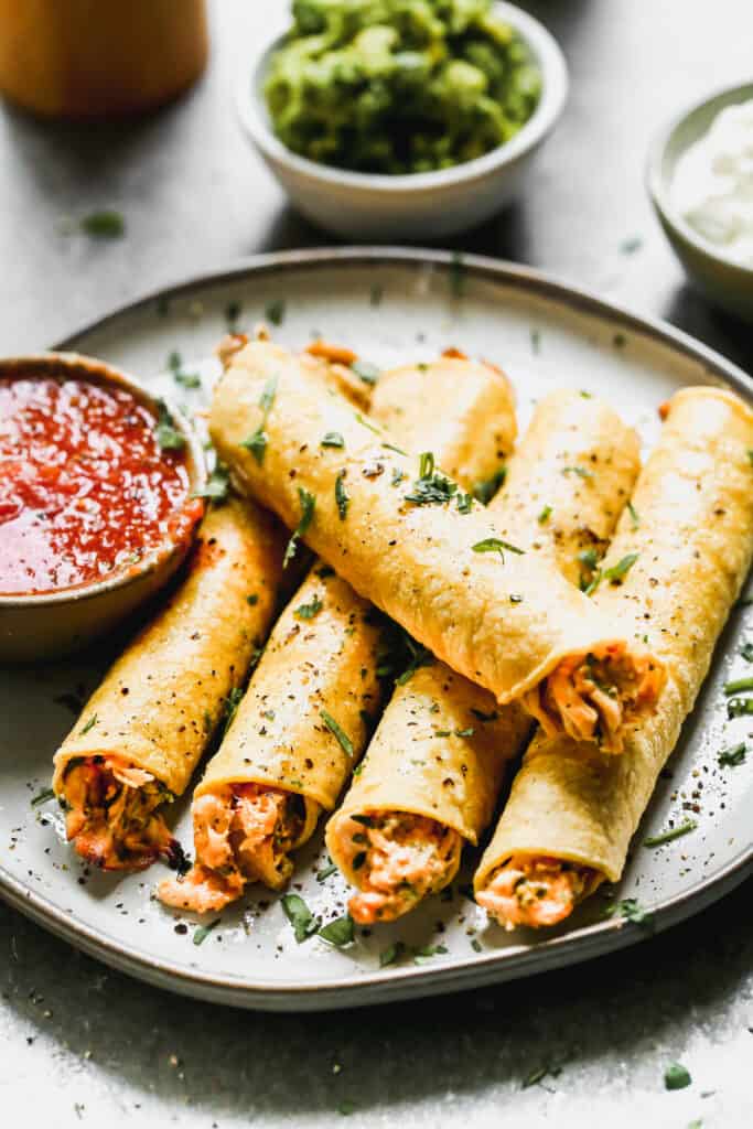 Baked chicken taquitos served on a plate.