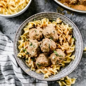 Swedish Meatballs served over egg noodles, in a bowl.