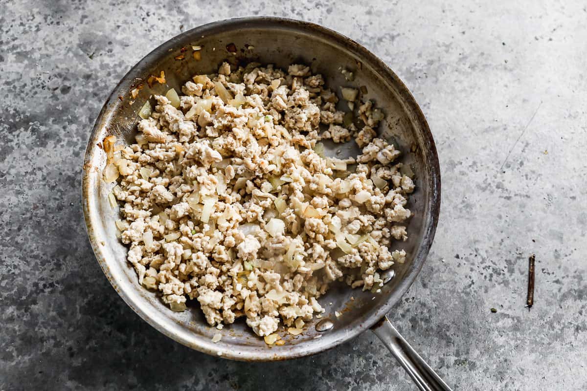 Ground chicken, garlic, onions, salt, and pepper in a stainless steel pan, all browned together. 