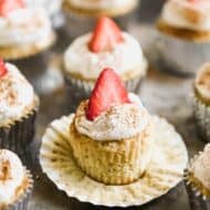 Tres Leches Cupcakes with whipped cream and a strawberry on top.