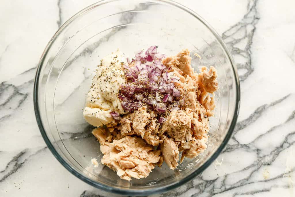 A bowl with tuna, mayo, lemon juice and chopped onion.