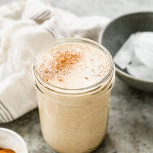 A homemade Vanilla Protein Shake in a mason jar and sprinkled with cinnamon.