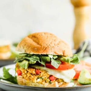 Veggie burger served on a wheat bun on a plate.