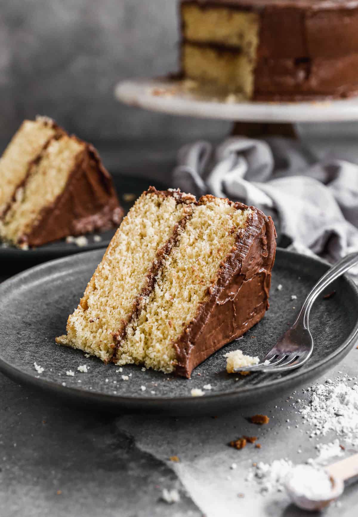 A slice of homemade Yellow Cake recipe with chocolate frosting, ready to enjoy.